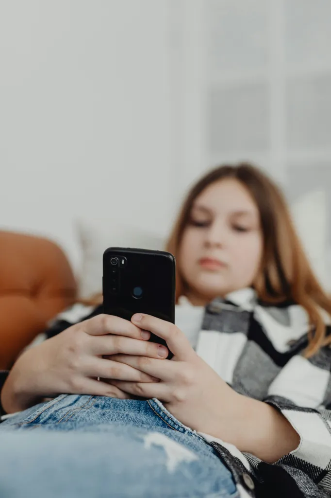Teenager using smartphone on the sofa